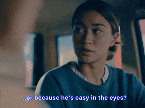 a woman in a blue sweater says " or because he 's easy in the eyes ? "