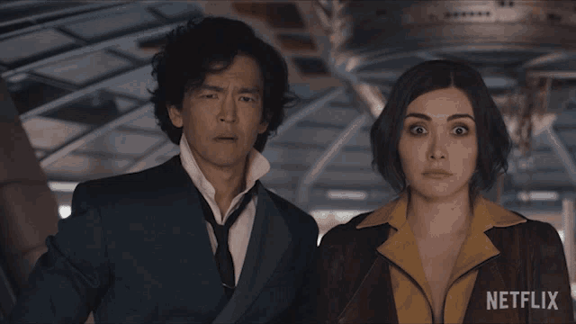 a man and a woman standing next to each other with netflix written on the bottom