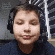 a young boy is wearing headphones and a microphone .