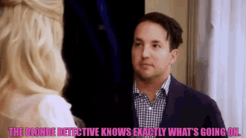a man in a suit and plaid shirt is talking to a blonde woman .