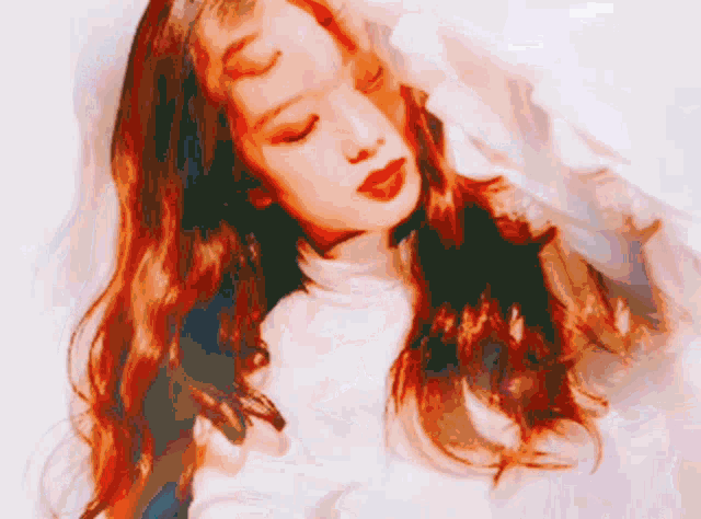 a woman with long red hair is wearing a white turtleneck sweater