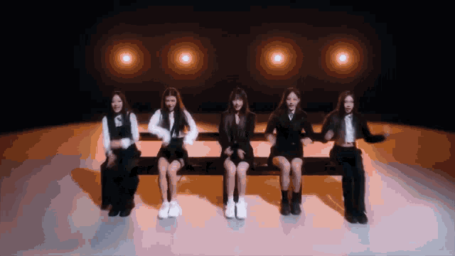 a group of women are sitting in a row on a stage
