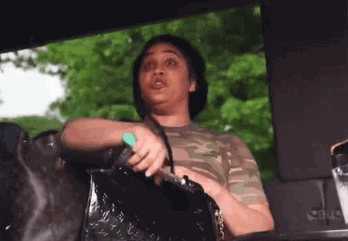 a woman is sitting in a car holding a purse and looking surprised .