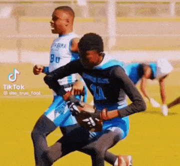a group of young men are playing a game of football .