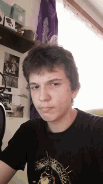 a young man is wearing a black shirt with a picture of a cow on it
