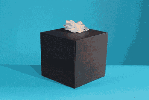 a person 's hand is sticking out of a box and giving a middle finger