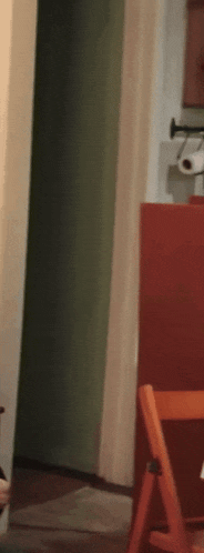 a person is standing in a room with a folding chair