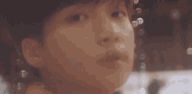 a close up of a man 's face with a blurry background and a light shining on it .