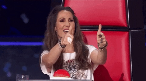 a woman is giving a thumbs up sign while sitting in a chair .