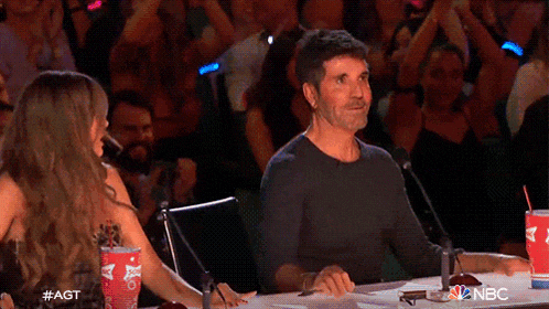a man and a woman are sitting at a table with a cup of budweiser in front of them