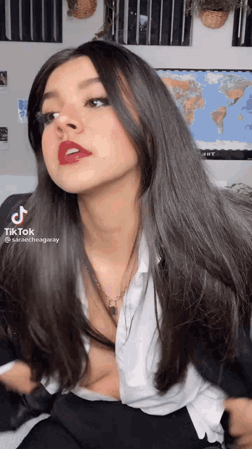 a woman with long dark hair is wearing a white shirt .