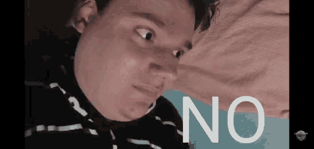 a man is laying on a bed with the word no in front of his face
