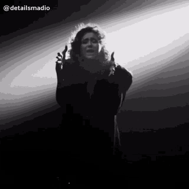 a black and white photo of a woman singing with detailsmadio in the upper right corner