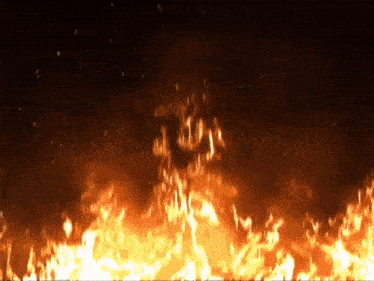 a large fire is burning in the dark against a black background .