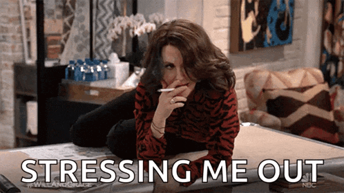 a woman is smoking a cigarette while laying on a bed and the words stressing me out are above her .