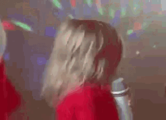 a little girl is singing into a microphone in a club .