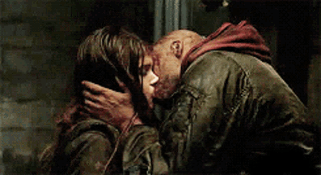 a man and a woman are kissing and the man has blood on his face