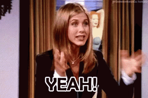 a woman is standing in front of a curtain with her arms outstretched and says yeah .