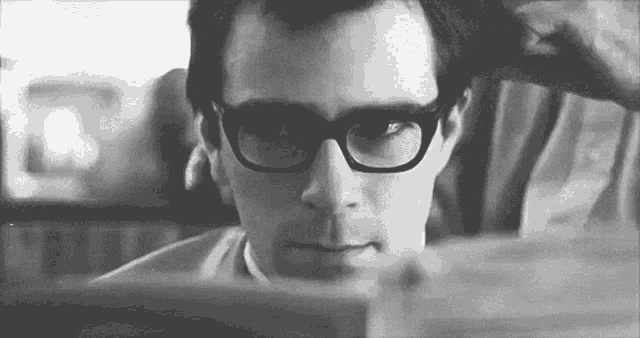 a black and white photo of a man wearing glasses