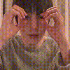 a person is covering their eyes with a smiley face