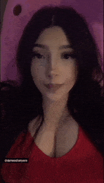 a woman in a red top covering her face with her hand