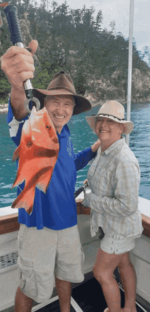 a man and woman on a boat with a man holding a fish
