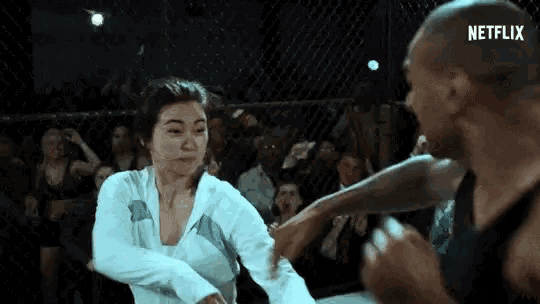 a woman is kicking a man in the face in a boxing ring .