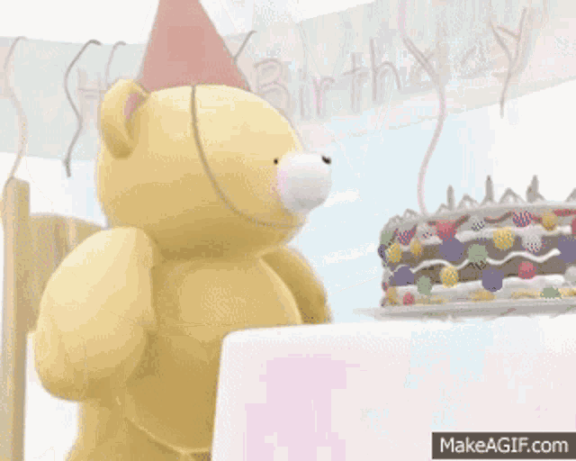a teddy bear wearing a party hat is eating a birthday cake