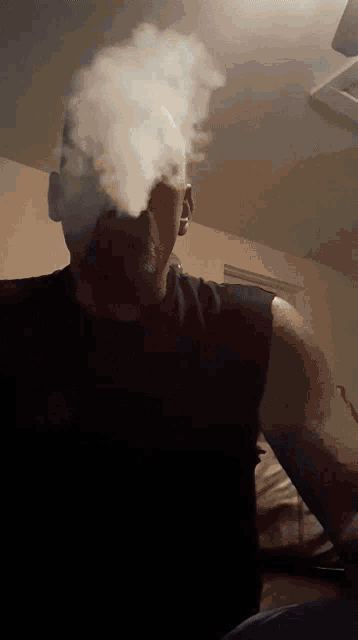 a man smoking a cigarette with smoke coming out of his nose