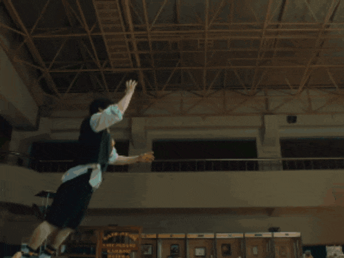 a man in a black shirt and black shorts is doing a trick on a skateboard