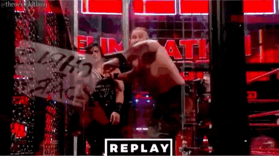 a couple of men standing next to each other in a wrestling ring with a sign that says `` replay '' .