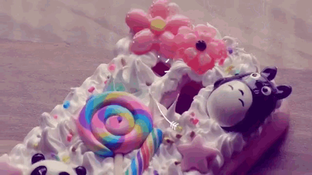 a cake with a panda and a lollipop on top
