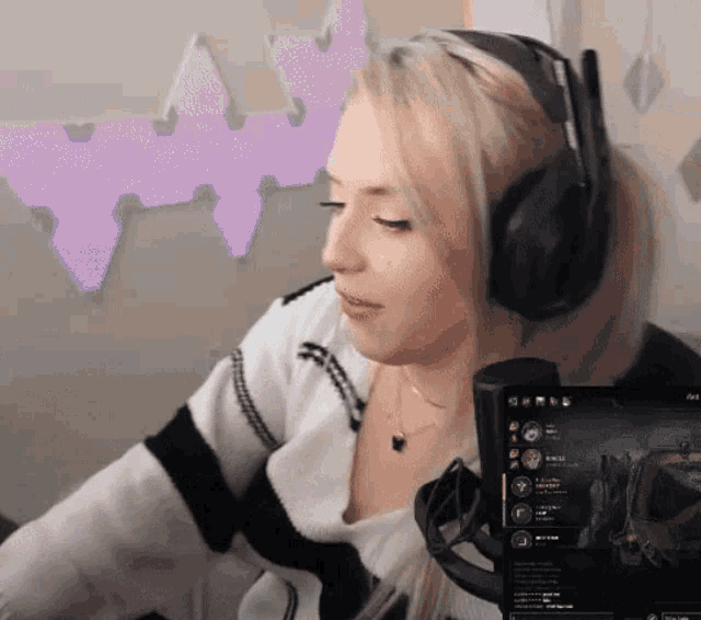 a woman wearing headphones is playing a video game on a computer screen