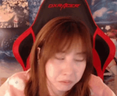 a woman sitting in a red and black dxracer chair