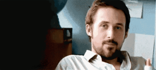 a man with a beard and a bandaged hand is sitting in a chair and looking at the camera .