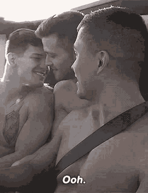 three men are hugging each other in a car and one of them is saying `` ooh '' .