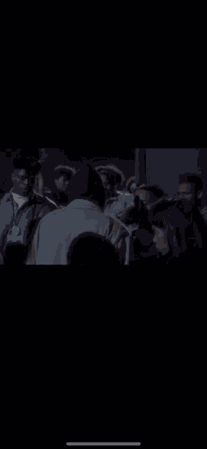 a man in a hooded jacket is standing in a crowd of people