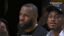 a man wearing a denim tears hat is sitting in the stands