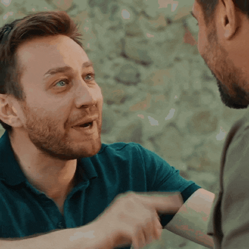 a man with a beard is talking to another man