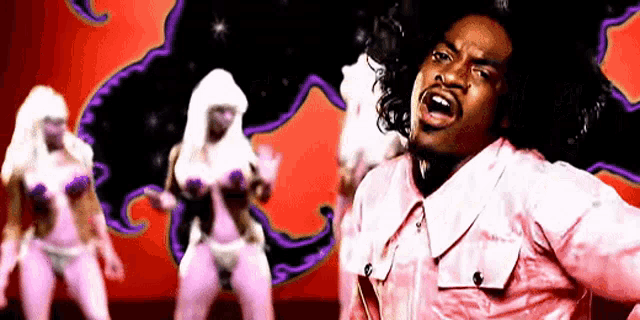 a man in a pink jacket is standing in front of a group of women .