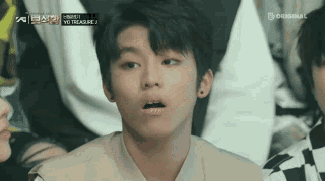 a young boy with a surprised look on his face is in front of a sign that says ' original '