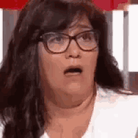 a close up of a woman wearing glasses making a funny face .