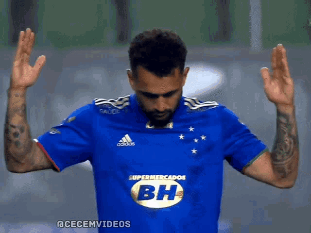 a man wearing a blue adidas shirt with bh on it