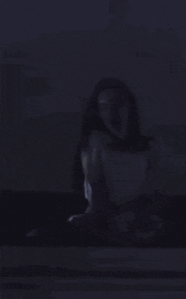 a woman in a white dress is sitting on a box