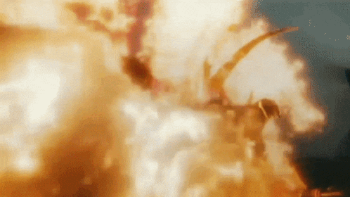a dragon is flying through the air in front of a large explosion .