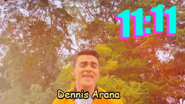 a man in a yellow jacket is singing in front of trees and the words dennis arana 11:11