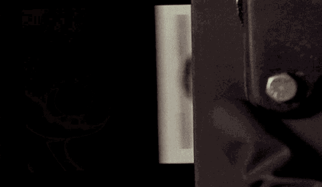 a black and white photo of a man 's face is being displayed on a black background