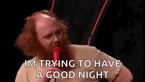 a man with a beard is singing into a microphone and saying `` i 'm trying to have a good night ''