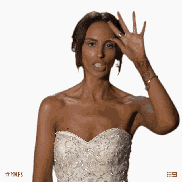a woman in a white dress is making a face with her hand