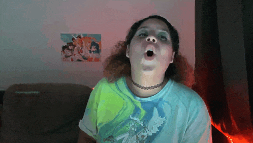 a woman wearing a choker and a t-shirt with a picture of angels on the wall behind her